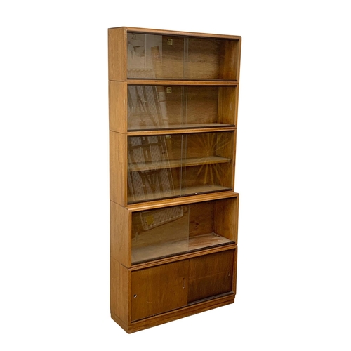 932 - A large vintage mahogany stacking bookcase. The Simplex Sectional Bookcase. 91.5 x 28 x 196.5cm.