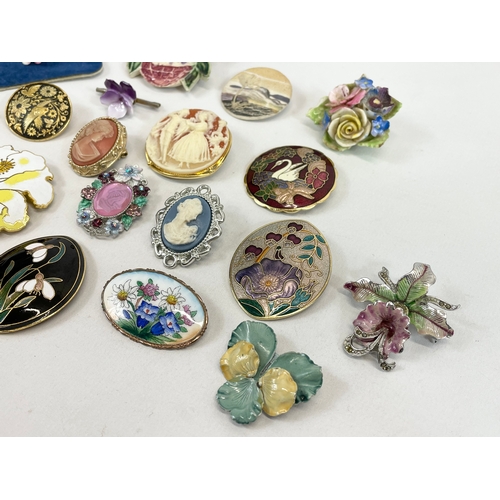 597 - A quantity of cameo, brass and porcelain brooches.