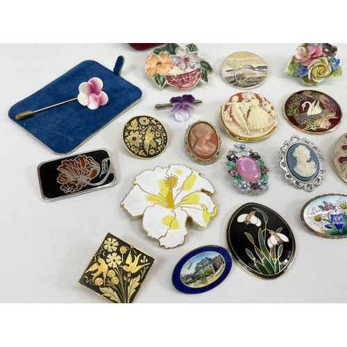 597 - A quantity of cameo, brass and porcelain brooches.