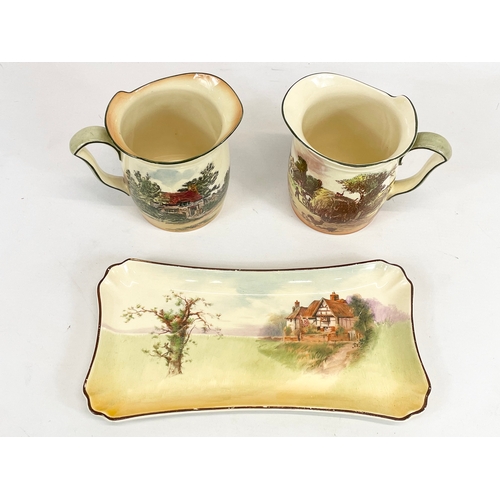 419 - 3 pieces of Royal Doulton “Rustic England” pottery. Plate measures 28cm. Jugs measure 15 x 12cm