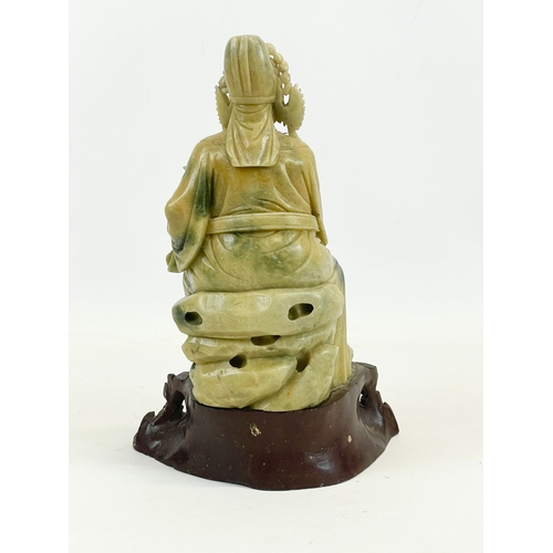 433 - An early 20th century Chinese soapstone figure on a carved wooden base. Circa 1900. 17 x 25cm