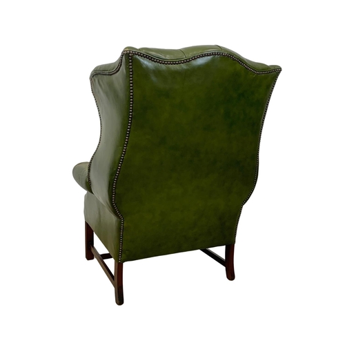 868 - A large Georgian style deep button leather wingback armchair. 82 x 94 x 112cm.