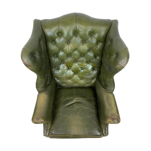 868 - A large Georgian style deep button leather wingback armchair. 82 x 94 x 112cm.