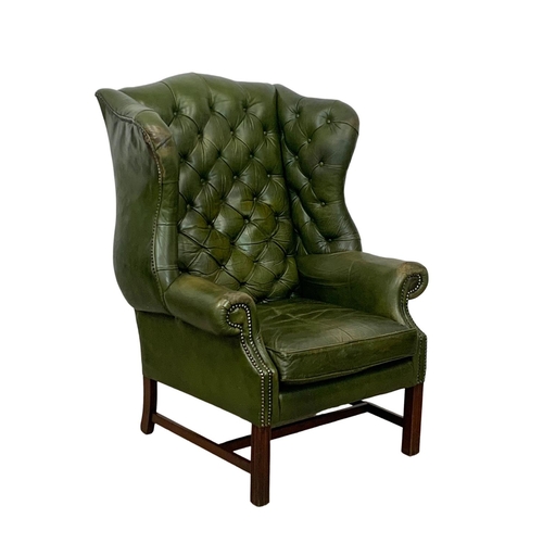 868 - A large Georgian style deep button leather wingback armchair. 82 x 94 x 112cm.