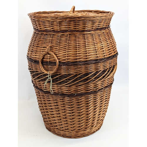 86 - A large wicker 2 handled linen hamper with lid.