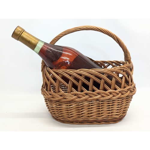 100 - A wicker ornamental basket with large Salingnac bottle. 38x37cm