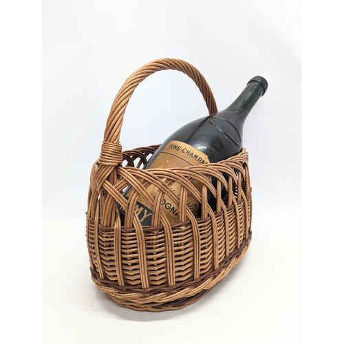 101 - A wicker ornamental basket with large Remy Martin cognac bottle. 44x36cm