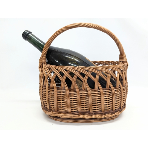 101 - A wicker ornamental basket with large Remy Martin cognac bottle. 44x36cm