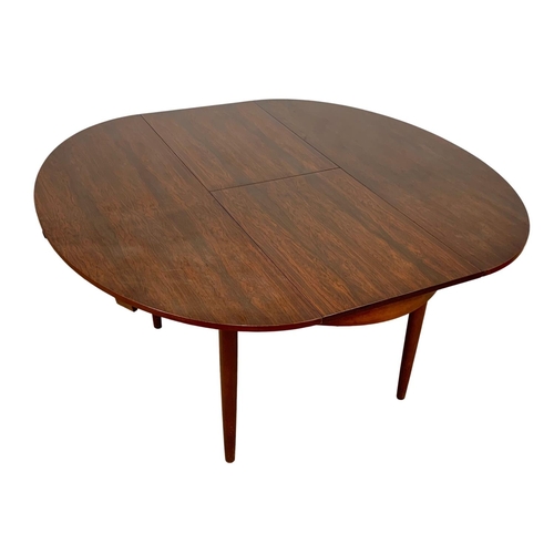 925 - A Greaves & Thomas rosewood extending Mid Century dining table. 1960’s. Open 142.5 x 138 x 74.5cm.