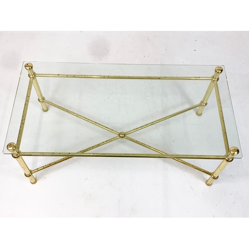 930 - A vintage Italian brass framed coffee table, with glass top. 110.5 x 55.5 x 45.5cm