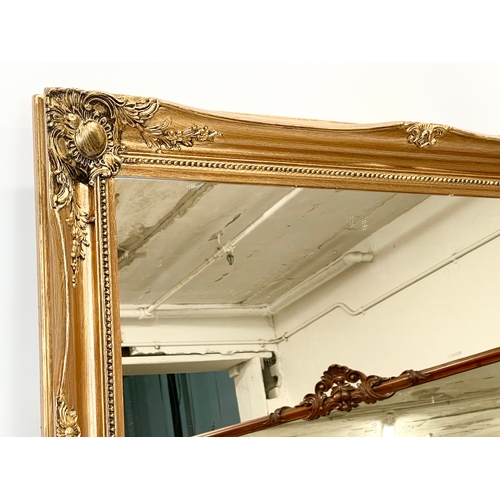 210 - An ornate gilt framed mirror. 90 x 64cm