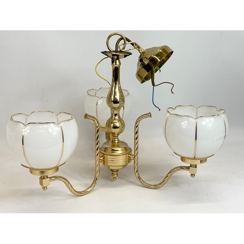 212 - A pair of brass chandeliers with glass shades. 44 x 45cm