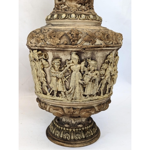 725 - A pair of large ornate 19th century pottery jugs, with Medieval figures. Tallest is 34cm