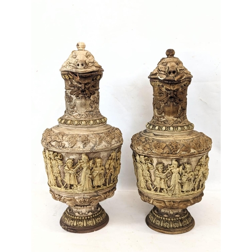 725 - A pair of large ornate 19th century pottery jugs, with Medieval figures. Tallest is 34cm