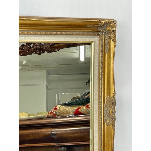 268 - An ornate gilt framed mirror. 92 x 67cm