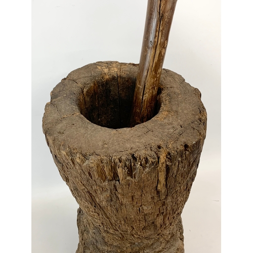 314 - A large early 20th century wooden mortar and pestle. 58cm.