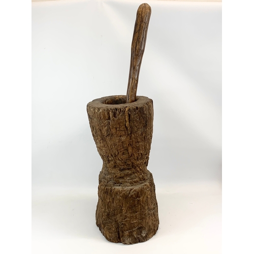 314 - A large early 20th century wooden mortar and pestle. 58cm.