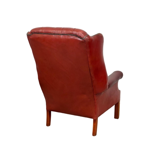 810 - A Georgian style deep button Ox-blood leather wingback armchair. 76 x 85