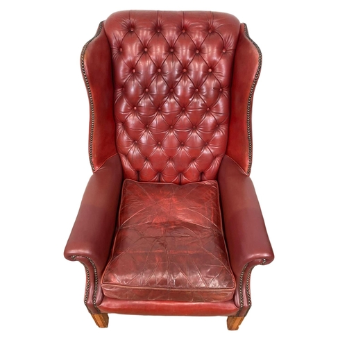 810 - A Georgian style deep button Ox-blood leather wingback armchair. 76 x 85