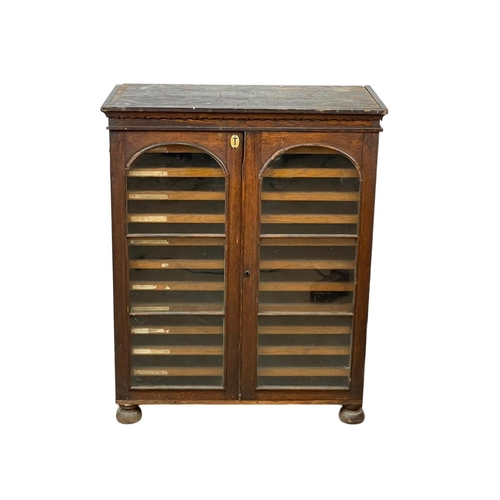 843 - A Victorian pine collectors cabinet, with 2 glazed doors and original scumble paint. 88 x 45 x 108cm