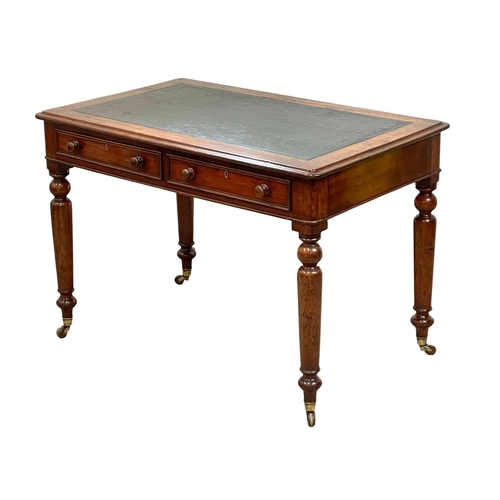 947 - A Victorian mahogany leather top writing table with 2 drawers and brass cup casters. 107 x 67 x 73cm