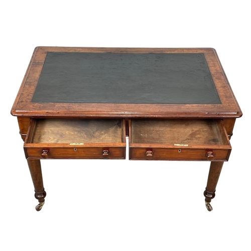 947 - A Victorian mahogany leather top writing table with 2 drawers and brass cup casters. 107 x 67 x 73cm