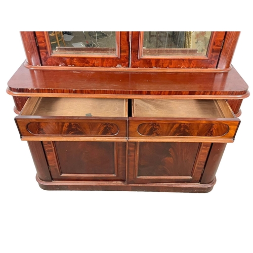 859 - A large Victorian mahogany bookcase, with mirrored doors and 2 drawers. 157 x 61 x 243cm