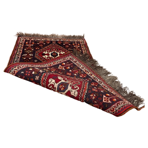 54 - A vintage Middle Eastern hand knotted rug. 68 x 133cm