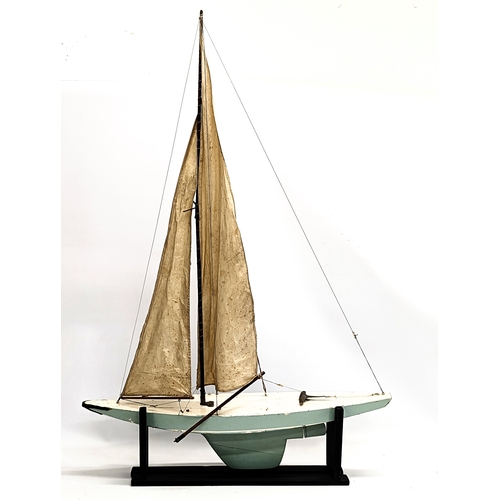 197 - A vintage model yacht on stand. 76x111.5cm