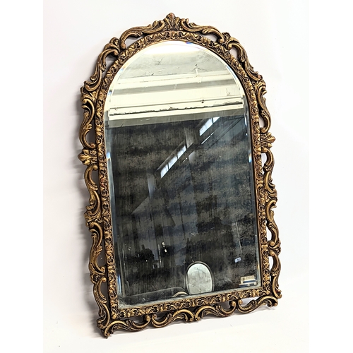116 - An ornate gilt framed mirror. 44.5x68.5cm