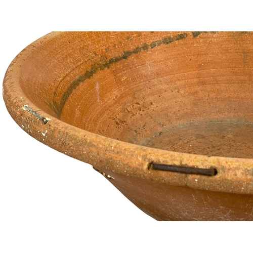 125 - A very large late 19th century French terracotta dough bowl. 71x22cm
