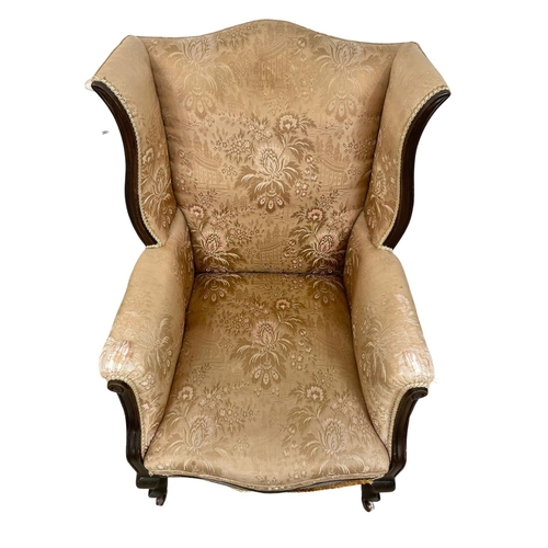 26 - An early 20th century mahogany framed wingback armchair. Circa 1920.