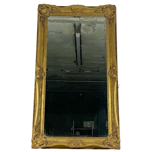 1040 - A large ornate gilt framed mirror. Carvers and Gilders. 80 x 141.5cm