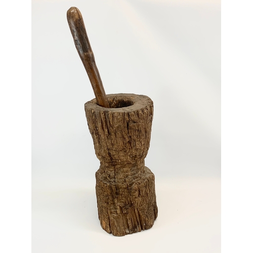 200A - A large early 20th century wooden mortar and pestle. 58cm.