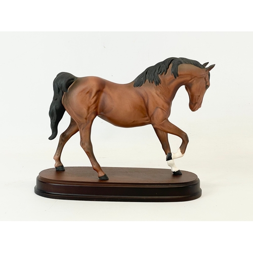 391 - A large Royal Doulton pottery horse on wooden stand. Spirit of Freedom. 26x21cm