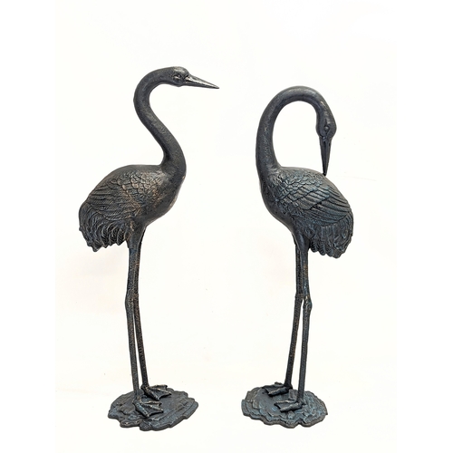 46 - A pair of large cast iron cranes. Tallest measures 75.5cm