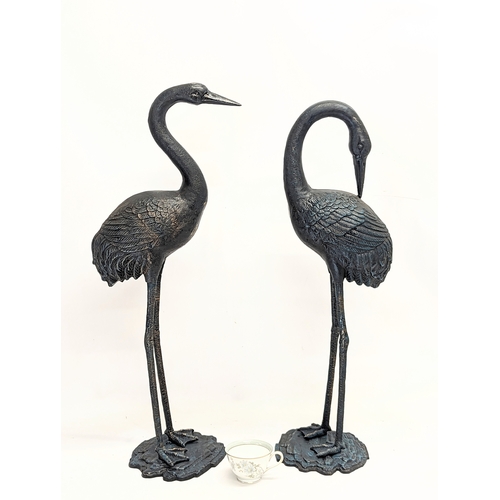 46 - A pair of large cast iron cranes. Tallest measures 75.5cm