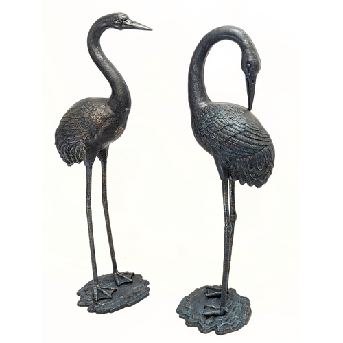 46 - A pair of large cast iron cranes. Tallest measures 75.5cm