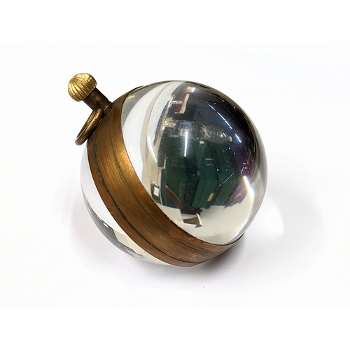 528 - An Omega style glass and brass globe clock. 6x8cm