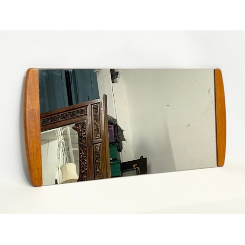 69 - A Mid Century teak framed mirror. 75x35.5cm