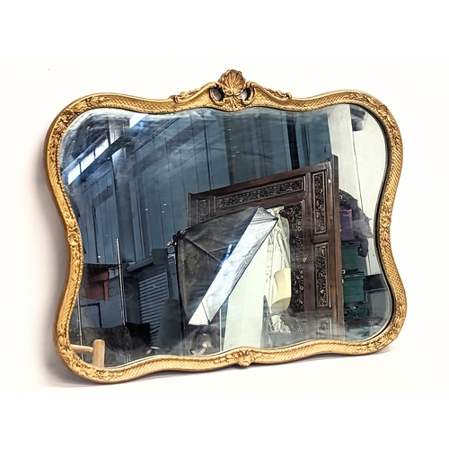 102 - An ornate gilt framed mirror. 71x55.5cm