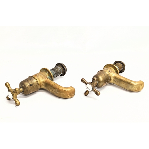 105 - A pair of Edwardian brass taps with a vintage hanging chain.