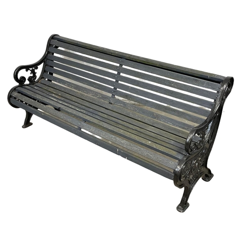 913 - A large early 20th century cast iron garden bench with wooden straps. Circa 1900-1920. 186x73x83cm