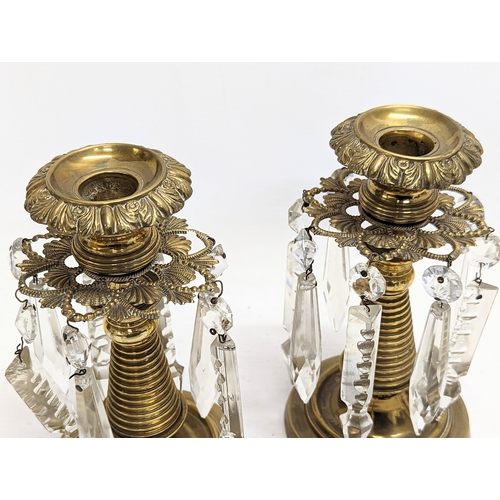 122 - A pair of Victorian brass candlesticks with glass droplets. 16.5xcm