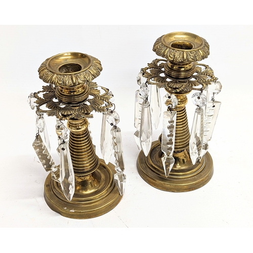 122 - A pair of Victorian brass candlesticks with glass droplets. 16.5xcm