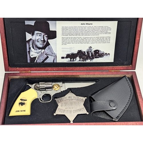 129 - A replica John Wayne pistol and badge