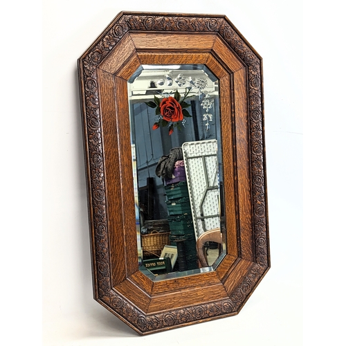 239 - A 1930s oak framed bevelled mirror. 52.5x83cm