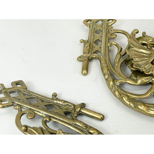 359 - A pair of ornate brass wall candle sconces with griffin decoration. 15cm