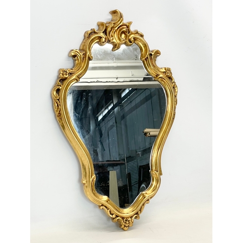 365 - An ornate gilt framed mirror in the Rococo style. Plastic. 43x70cm