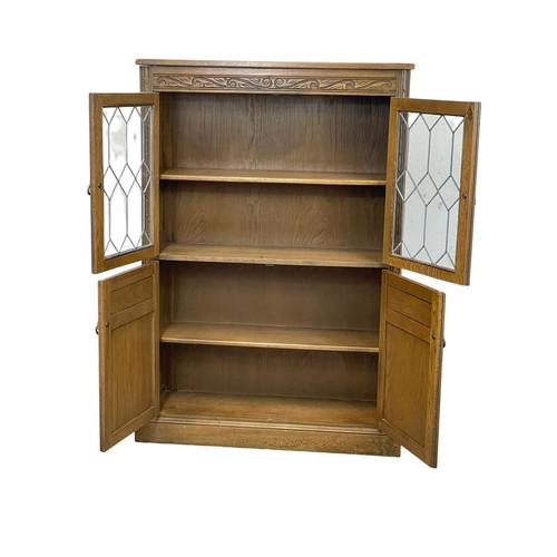 322 - An oak side cabinet with lead glass doors. 94x33x137cm